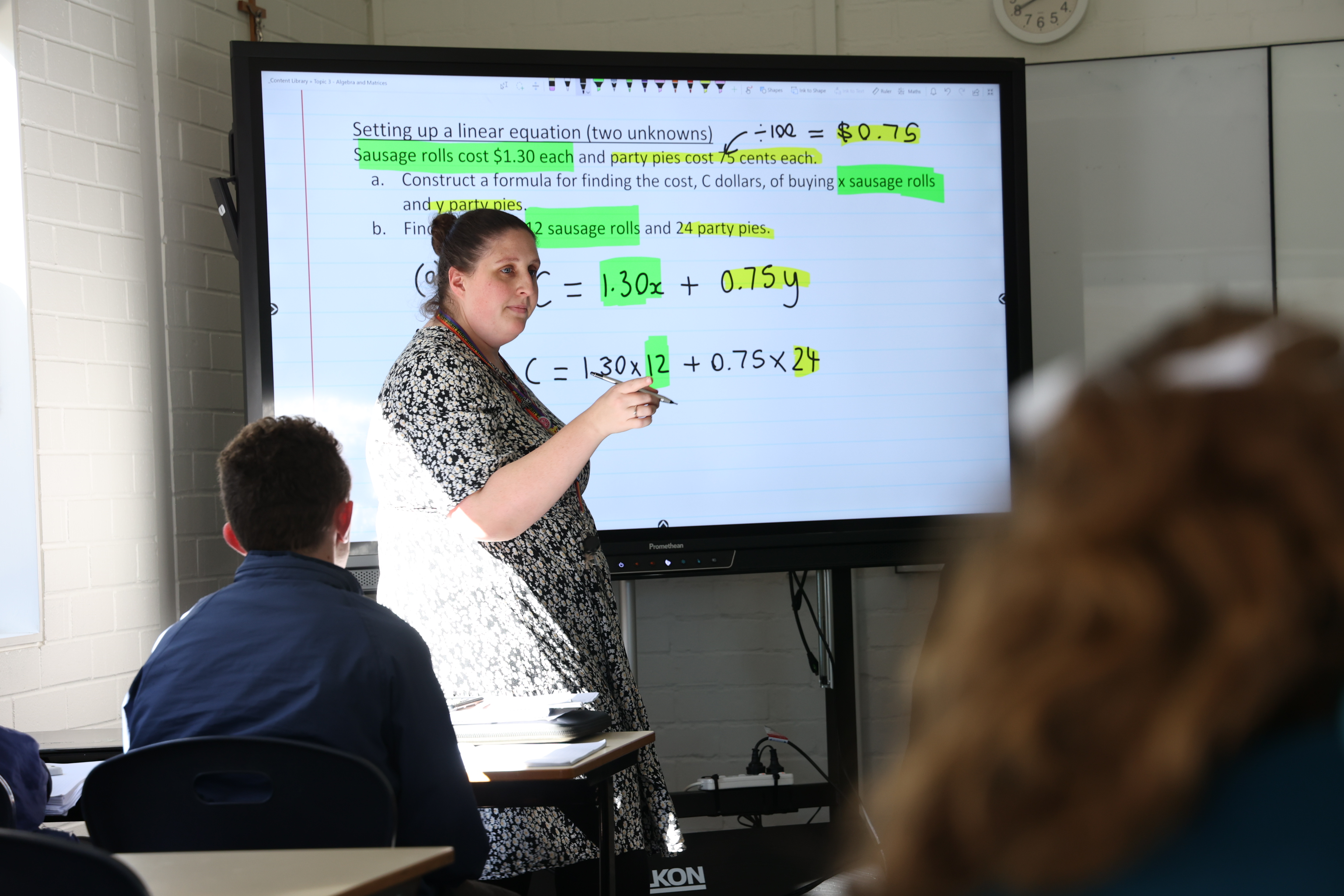 Teacher using an interactive screen connected to a laptop.